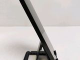 a small black cell phone on a stand on a table