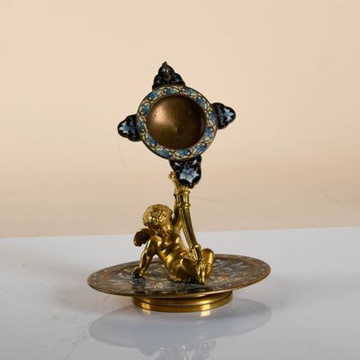 a gold and blue candle holder on a white table