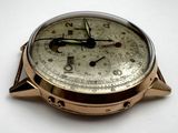 a close up of a gold watch on a white surface