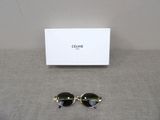 celine sunglasses in black and gold with a white box on a gray surface