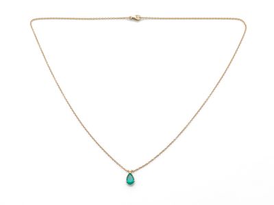 un collier en or avec un pendentif en forme de larme verte au bout d'une chaîne