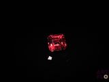 a close up of a red diamond on a black surface