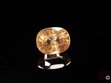 un diamant jaune sur une surface noire, avec un fond noir