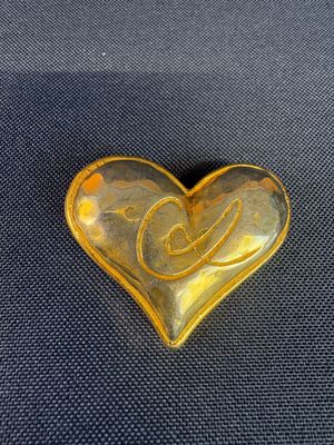a yellow heart shaped stone with a swirl on it