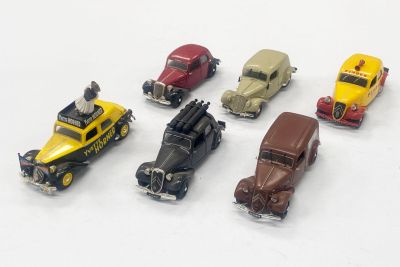plusieurs petites voitures sont alignées sur une surface blanche