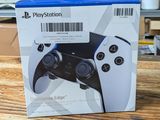 the box is open on a wooden table with a game controller in it