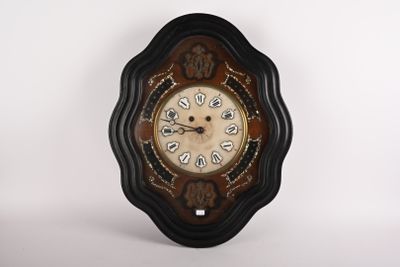 une horloge accrochée au mur devant un fond blanc