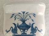 a blue and white plate with a bird and a vase on it