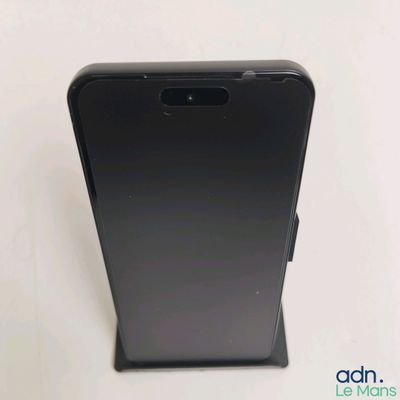 un gros plan sur l'arrière d'un téléphone noir posé sur une surface blanche