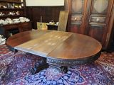 a large wooden table with two leaves on top of it