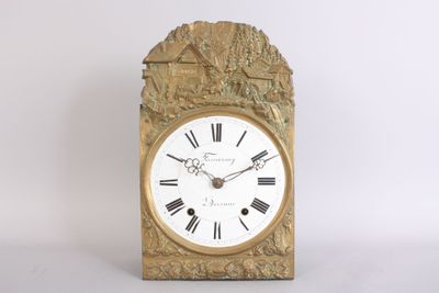 a gold clock with roman numerals on the face