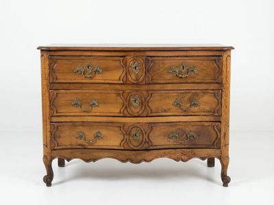 une commode ancienne dont les tiroirs sont ornés de sculptures élaborées