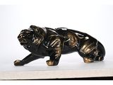 a black and gold statue of a dog on a white surface