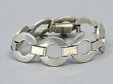 silver bracelet with circles and links on a white background