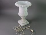 a white vase with a cord attached to it