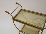 a small metal cart with a glass top on a white surface