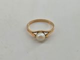 a close up of a gold ring with a pearl on it