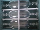 four empty wine glasses in a box with a white handle