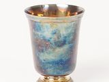 a silver cup with a blue and gold design on it