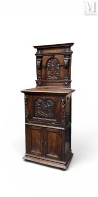 une vieille armoire en bois ornée de sculptures sur le dessus