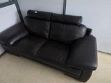 a black leather couch sitting in a corner of a room