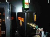 a beer dispenser with a bottle on top of it
