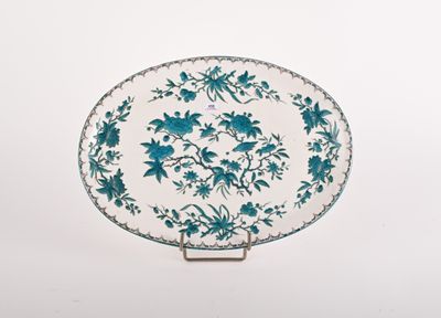 blue and white plate with flowers on it on a stand