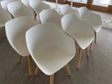 many white chairs sitting in a row in the middle of a room
