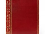un livre en cuir rouge avec des finitions dorées et une bordure dorée