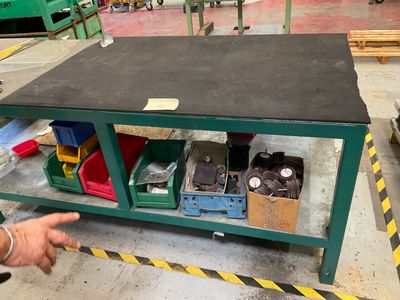 un homme qui montre du doigt une table sur laquelle se trouvent de nombreux objets