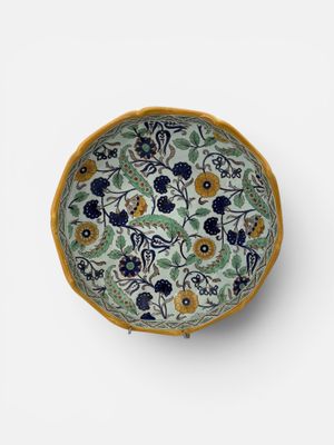 GIEN Plat creux en faïence à décor de rinceaux fleuris et de…