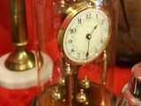 a glass dome with a clock inside of it on a table