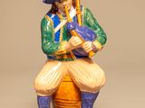 une figurine représentant un homme jouant d'un instrument de musique