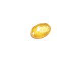 a close up of a yellow gemstone on a white surface