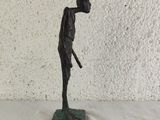 statue of a man holding a golf club on a green base