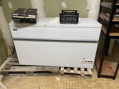 a white refrigerator sitting in the middle of a room under construction