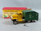 un camion jouet jaune et vert à côté d'une boîte rouge