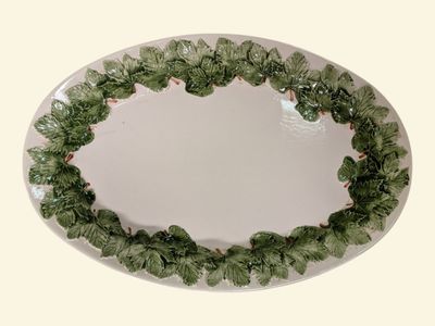 a white plate with a green leaf decoration on it