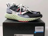 une paire de chaussures de course noires et blanches posée sur une boîte