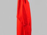 a red coat on a mannequin stand against a gray background
