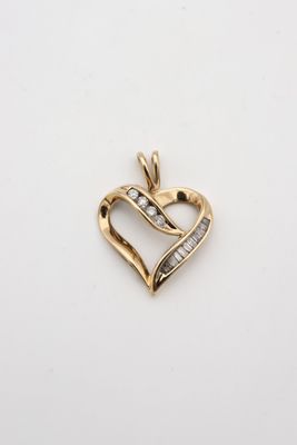 un pendentif en forme de cœur en or serti de diamants sur fond blanc