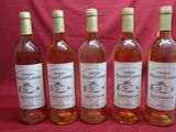 six bottles of wine are lined up on a red cloth