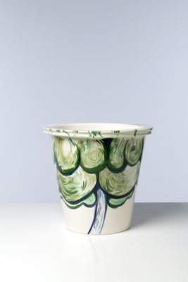 une tasse blanche ornée d'un motif vert et bleu