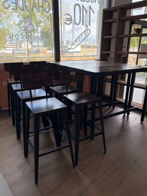 des tables et des tabourets devant une grande fenêtre dans un restaurant