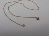 a gold chain with a small heart charm on it