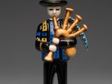 figurine représentant un homme jouant de la cornemuse et tenant une cornemuse