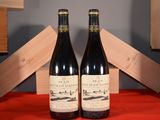 two bottles of wine sitting next to each other on a table