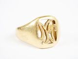 un gros plan d'une bague en or portant un monogramme