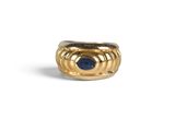 a close up of a gold ring with a blue stone