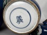 a blue and white vase sitting next to a blue and white vase